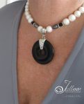 black-donut-and-white-pearl-necklace-on-grey.1